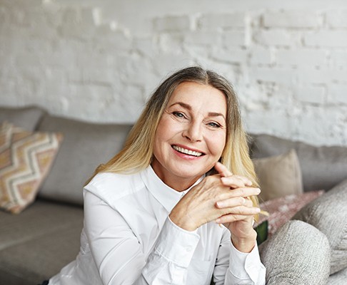 Senior woman sitting on couch and smiling