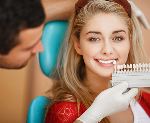 A dentist assessing a woman for teeth whitening