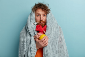 Man wrapped in a blanket and preparing for flu season