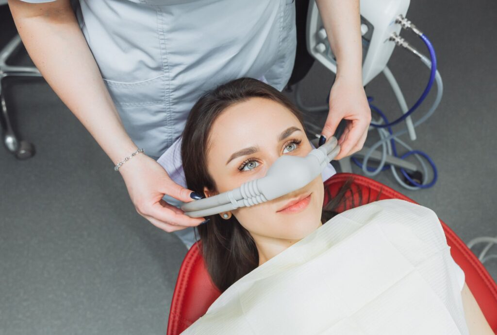 Woman in dental chair with nitrous oxide mask over nose